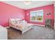 Bright pink bedroom featuring a bed, window, and built in bookcase at 4535 Falls Lake Sw Dr, Concord, NC 28025