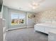 Light-filled bedroom with large window, floral wallpaper, and plush white bedding at 4535 Falls Lake Sw Dr, Concord, NC 28025