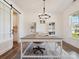Home office with neutral paint, wood floors, large desk, and a stylish light fixture at 4535 Falls Lake Sw Dr, Concord, NC 28025