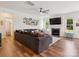 Spacious living room with wood flooring, a fireplace, large windows, and a ceiling fan at 4535 Falls Lake Sw Dr, Concord, NC 28025