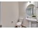 Modern half bathroom with pedestal sink, round mirror, and wood-look flooring at 505 Silers Bald Dr, Fort Mill, SC 29715