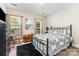 Bedroom with a metal bed frame, a rocking chair, and two windows that let in natural light at 6029 Phyliss Ln, Mint Hill, NC 28227
