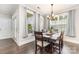Bright dining room with a dark wood table set, chandelier lighting, and natural light from large windows at 6029 Phyliss Ln, Mint Hill, NC 28227
