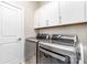 Functional laundry room with modern washer and dryer set and ample white cabinet storage space at 6029 Phyliss Ln, Mint Hill, NC 28227