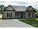 Charming brick home with black accents, cozy front porch and a long driveway at 604 E Ohio Ave, Bessemer City, NC 28016