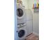 Compact laundry room with stacked washer and dryer, plus convenient shelving at 604 E Ohio Ave, Bessemer City, NC 28016