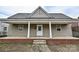 Charming home featuring a quaint front porch, neutral siding, and well-maintained landscaping at 613 E Liberty St, Salisbury, NC 28144