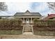 A charming view of the home's front exterior with covered porch and mature hedges at 613 E Liberty St, Salisbury, NC 28144