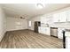 Spacious living room and kitchen combo featuring white walls, wood-look flooring, and stainless steel appliances at 613 E Liberty St, Salisbury, NC 28144