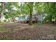 Outdoor living in a shady backyard with mature trees, deck, and ample space for recreation at 636 Forest Nw St, Concord, NC 28025