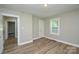 A neutral bedroom with wood-look flooring features a closet and a large window at 636 Forest Nw St, Concord, NC 28025
