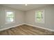 A spacious bedroom with natural light features wood-look flooring and neutral walls at 636 Forest Nw St, Concord, NC 28025