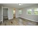 A bedroom with wood-look flooring and natural light features multiple windows at 636 Forest Nw St, Concord, NC 28025