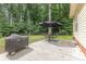 Backyard with lush trees, a covered grill, and patio dining set at 713 Hickory Hill Ct, Gastonia, NC 28054