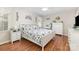 Comfortable bedroom featuring wood floors, a ceiling fan, and a queen-sized bed with white floral bedding at 713 Hickory Hill Ct, Gastonia, NC 28054