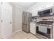 Functional kitchen equipped with stainless steel appliances, ample storage, and tile flooring at 713 Hickory Hill Ct, Gastonia, NC 28054