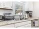 A well-lit kitchen with stainless steel sink, granite countertops, and white cabinetry at 713 Hickory Hill Ct, Gastonia, NC 28054