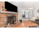 Spacious living area with a brick fireplace, hardwood flooring, and an open view to the dining area at 713 Hickory Hill Ct, Gastonia, NC 28054