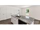 Kitchen featuring a gray granite kitchen island with stainless steel sink and modern appliances at 812 Generation Ln, Clover, SC 29710