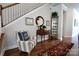 Charming foyer with hardwood floors, a decorative mirror, and a cozy chair by the staircase at 914 Greenbridge Dr, Matthews, NC 28105