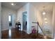 Hallway with hardwood flooring, staircase, and stylish pendant lights at 914 Greenbridge Dr, Matthews, NC 28105