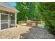 Back patio with outdoor kitchen, grill, and wooded views beyond at 9330 Carneros Creek Rd, Charlotte, NC 28214