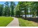 Concrete walking path with green grass and trees along a lake at 9330 Carneros Creek Rd, Charlotte, NC 28214