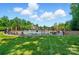 Community pool with lounge chairs, umbrellas, and lawn area at 9330 Carneros Creek Rd, Charlotte, NC 28214