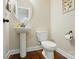 Cozy powder room featuring pedestal sink, toilet, and a decorative mirror at 9330 Carneros Creek Rd, Charlotte, NC 28214