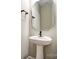 Powder room featuring a pedestal sink, unique mirror and modern fixtures at 9662 Liberty Hill Dr, Mint Hill, NC 28227