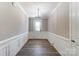 Inviting foyer featuring decorative wall panels, wood flooring, and a front door with glass panels at 9662 Liberty Hill Dr, Mint Hill, NC 28227