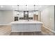Modern kitchen features a large island, pendant lighting, stainless steel appliances, and sleek white cabinetry at 9662 Liberty Hill Dr, Mint Hill, NC 28227