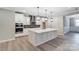 Modern kitchen features a large island, pendant lighting, stainless steel appliances, and sleek white cabinetry at 9662 Liberty Hill Dr, Mint Hill, NC 28227