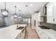Modern kitchen featuring an island with a sink and white cabinetry, showcasing a sleek and functional design at 9662 Liberty Hill Dr, Mint Hill, NC 28227