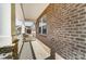 Side porch showing brickwork, white columns, and a view of the neighboring house with a white picket fence at 9662 Liberty Hill Dr, Mint Hill, NC 28227