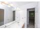 Bathroom featuring large mirror, bright vanity lighting, and single sink at 10408 Hadleigh Pl, Charlotte, NC 28210