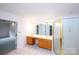 Bright bathroom with dual sinks, wooden cabinets, tile flooring, and glass enclosed shower at 10408 Hadleigh Pl, Charlotte, NC 28210