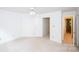 Spacious bedroom with neutral carpet, ceiling fan, and two entrances to hallway and bath at 10408 Hadleigh Pl, Charlotte, NC 28210