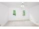 Bright bedroom with neutral carpet, ceiling fan, and double windows showcasing the greenery outside at 10408 Hadleigh Pl, Charlotte, NC 28210