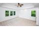 Bright bedroom with carpet, a ceiling fan, and large windows overlooking greenery at 10408 Hadleigh Pl, Charlotte, NC 28210