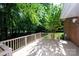 Deck with wood railing that overlooks a wooded area, and brick on the exterior of the home at 10408 Hadleigh Pl, Charlotte, NC 28210
