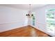 Light dining room with dark wood floors and decorative light fixture at 10408 Hadleigh Pl, Charlotte, NC 28210