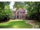 Traditional two-story brick home with well-maintained lawn and mature trees at 10408 Hadleigh Pl, Charlotte, NC 28210
