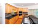 Corner view of an open kitchen with black countertops and double sink at 10408 Hadleigh Pl, Charlotte, NC 28210