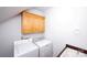 Functional laundry room with washer, dryer, sink, and overhead storage at 10408 Hadleigh Pl, Charlotte, NC 28210