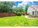 Lush backyard with a brick perimeter, green lawn, landscaping, and bench seating at 10418 Pullengreen Dr, Charlotte, NC 28277