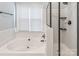 This bathroom features a separate tub and shower with tiled surround and black fixtures at 10418 Pullengreen Dr, Charlotte, NC 28277