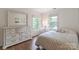 Cozy bedroom with hardwood floors, dresser, and windows with natural light at 10418 Pullengreen Dr, Charlotte, NC 28277