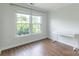 Bedroom features hardwood floors, natural light, and a sleek writing desk at 10418 Pullengreen Dr, Charlotte, NC 28277