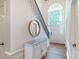 Inviting foyer with hardwood floors, elegant lighting, and a grand staircase with arched window at 10418 Pullengreen Dr, Charlotte, NC 28277